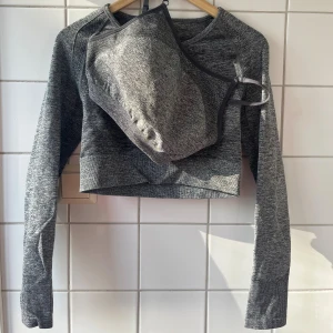 Gymshark träningsset - Grå matchande sport-bh och croppad topp från Gymshark. Sport-bh storlek M, topp storlek L. Använda fåtal gånger, fint skick! Lappar bortklippta.