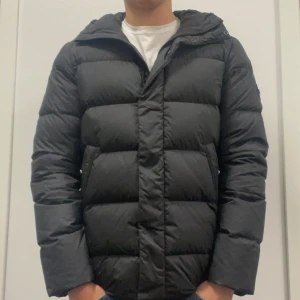 J.LINDEBERG VINTERJACKA - Säljer nu min svarta dunjacka från J.Lindeberg i storlek S då den blivit för liten. Har endast använts en vinter och är i fint skick.                 OBS! Fläcken på ryggen har tvättats bort och man kan endast se spår av den från ~20 cm avstånd.