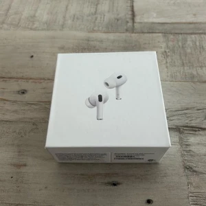 AirPods Pro 2 - Apple AirPods Pro i originalförpackning, helt nya och oöppnade. Trådlösa hörlurar med aktiv brusreducering, transparensläge och bekväm passform. Perfekt för musik, samtal och träning. Laddningsetui ingår.