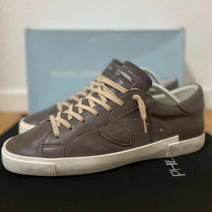 Philippe Model skor - Säljer dessa riktigt snygga brunbeiga Philippe model skor i mycket bra skick! Skorna är i storlek 44 och orginalbox ingår vid köp! Nypriset ligger på 3500 kr!!! Skorna är använda ett fåtal gånger! Hör av er ifall ni har några frågor!