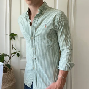 Ralph Lauren skjorta grön vit randig M - Ralph Lauren skjorta grön vit randig M slim fit stretch Oxford. Inga defekter, lite liten i storlek. Modellen är 180,75 kg. Kom med frågor 🫶
