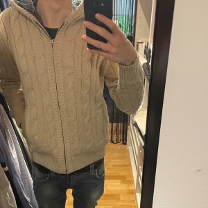 Kabelstickad cardigan - As fett och mysig kabelstickad cardigan/zip tröja, helt perfekt till höst och vinter då den är otroligt varm och snygg, osäker vad för märke men den är storlek S och kan nog passa M