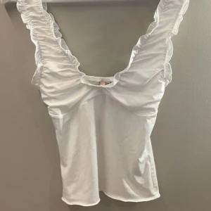 Vit topp Nelly  - Supersöt vit topp från Nelly!         Jag säljer denna top för att den inte kommer till användning💕💕