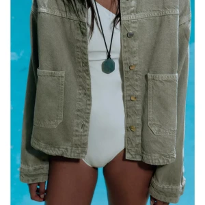 Grön jeansjacka från Zara - Skitsnygg  grön jeansjacka från Zara med klassisk krage och stora fickor framtill. Jackan har tryckknappar och är tillverkad i ett slitstarkt bomullsmaterial. Passformen är loose och ärmarna är långärmade. Aldrig använd!! Nyskick 💘💘 Pris kan diskuteras vid snabb affär!!