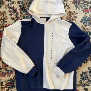 Blåvit hoodie från Poetic Collective - Säljer en snygg hoodie från Poetic Collective i blått och vitt med coolt blockmönster. Storlek L. Tröjan har huva, känguruficka och lång ärm. Vertikal logga på framsidan ger extra stilpoäng. Perfekt för chill dagar eller streetwear.