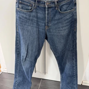 Blå relaxed jeans från Jack & Jones - Snygga blå jeans från Jack & Jones i modellen Relaxed/Chris. Jeansen har en avslappnad passform med raka ben och klassiska fem fickor. Tillverkade i slitstarkt denim med kontrastsömmar och normal midja. Perfekta för en chill och stilren look.