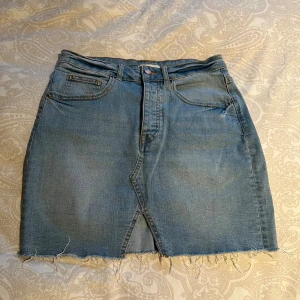 Blå jeanskjol från g perfect jeans - Säljer en blå jeanskjol från g perfect jeans i storlek 36. Fransig fåll och har klassiska femficksdetaljer samt en liten slits framtill.
