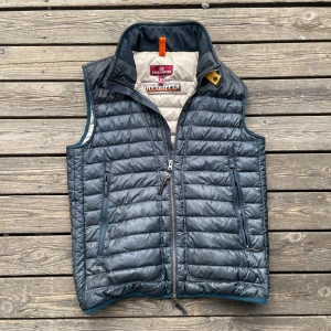 Parajumper Väst - Säljer min blåa parajumper day tripper väst. Perfekt nu till hösten eftersom det är en varmare/tjockare väst. 7/10 skick, använd men inga defekter. Lite misfärgningar på insidan men syns inte vid användning. Han på bilden är 183 cm 70kg. Nypris ca 4000kr. Äkthetsbevis finns, hör av dig vid minsta fundering.