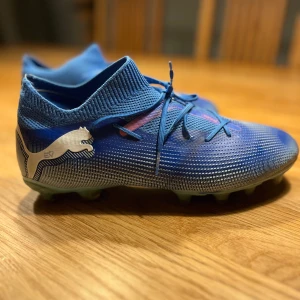 Blåa Puma fotbollsskor strl 40 - Säljer ett par blåa Puma fotbollsskor i storlek 40. Använda 3 månader så är som nya. Nypris 1100:-