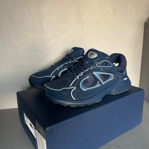 Blå Dior B30, s43 - Tja! Säljer mina Dior B30 sneakers, Dom är i bra skick, fick dom av min morsa, man får med dustbag, box, påse och extraskosnören, säljer dom pga att jag behöver mer pengar. Det är bara att skicka om ni har några frågor eller vill ha mer bilder så svarar jag så fort jag kan, mvh.