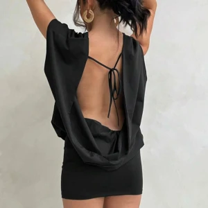 Svart kort klänning med öppen rygg - Snygg svart kort klänning med lös passform upptill och tight kjol. Klänningen har öppen rygg med knytband och korta ärmar💗 super stretchig, aldrig använd