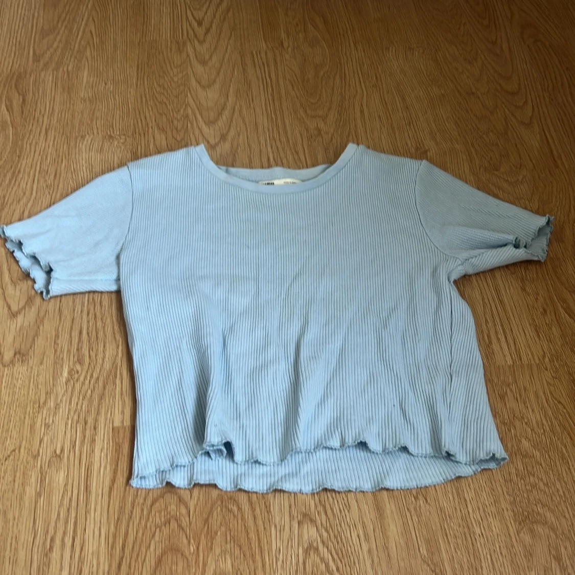 Ljusblå ribbad topp med volangkant