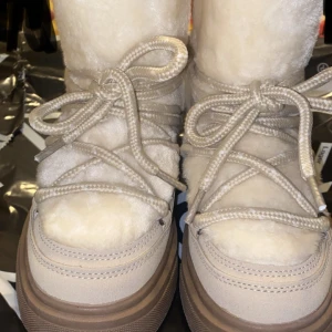 Beiga moon boots med snörning - Supermysiga beiga moon boots från 157 med fluffig insida och grov sula. Skorna har snörning framtill och är fodrade med mjukt syntetmaterial som håller dig varm. Perfekta för kalla vinterdagar och har en chunky look med högt skaft.