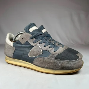 PHILIPPE MODEL TRPZ - Säljer ett par mörkblåa Philippe Model sneakers med vita detaljer. Tillverkade i en mix av skinn och mocka för en nice look. Perfekt för dig som letar efter stiliga vinterskor. Bara skorna ingår. Skick: 9/10. Vid frågor och funderingar så tveka inte att fråga ;)