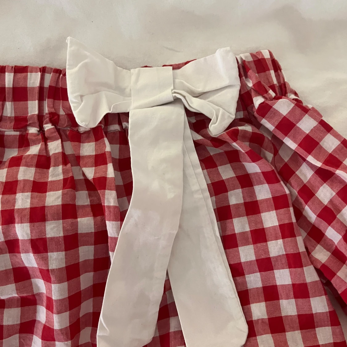 Rutig röd klänning med rosett - 1