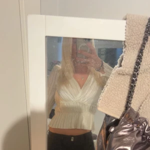 Vit omlott blus med volang - Säljer en vit omlott blus med v-ringning och volangdetaljer. Blusen har långa, lätt puffade ärmar och ett ribbat midjeparti som ger en snygg siluett. Perfekt för dig som gillar romantisk och trendig stil. Kan mötas upp i Stockholm!! 