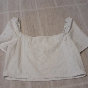 Vit blus från Shein med broderi - Säljer en söt vit blus från Shein i storlek 11-12 år som motsvarar ungefär xs. Blusen har korta ärmar och är croppad med broderade detaljer och små hålmönster. Skriv för frågor osv!💕 (ENDAST SWISH)