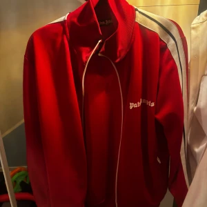 Palm zip hoodie - En röd palm angels zip hoodie, knappt använd alls. Storlek S men passar även M