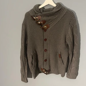 Grå kofta  - Tja säljer denna gråa kofta med väldigt unika spännen. Den kofta är unknown och är svår att hitta information om. Sitter riktigt skönt och sitter som en stor M. Hör gärna av er för fler frågor! 