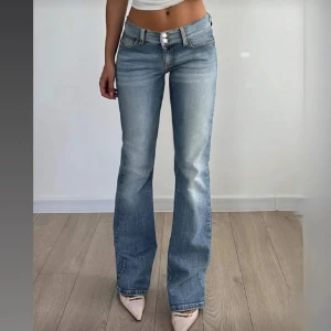 Bootcut ljusblå jeans med låg midja - Snygga midwaist jeans i ljusblå med bootcut-ben med fickor. Jeansen har dubbla knappar i midjan och dragkedja. Dom är stretchiga och helt oanvända. Rekommenderar dom till kortare tjejer jag är 169 cm o dom går ner till strax över vaderna på mig.
