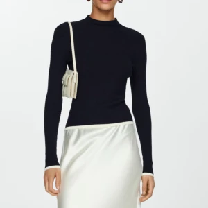 Ribbad tröja med mock neck - Helt oanvänd. Mörk marinblå ribbad tröja med mock neck-krage. Stretchigt och mjukt material som lägger sig fint på kroppen. Den ser riktigt classy ut och passar i alla sammanhang. Ordinarie pris 419kr.