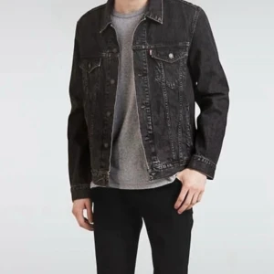 Svart jeansjacka med tryck på ryggen - Säljer en svart jeansjacka från Levi's med klassisk krage, knappar framtill och två bröstfickor med lock. Jackan har ett stort, coolt tryck på ryggen i vitt och grått. Passformen är normal och materialet är robust denim. Perfekt för dig som gillar streetstyle. Snabb leverans 📦 XS men passar Small Storlek 