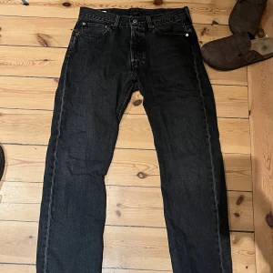 Svarta Levi's 501 jeans W33 L30 - Svarta Levi's 501 jeans med klassisk rak passform och knappgylf. I princip oanvända och i nyskick.