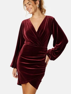 Vinröd sammetsklänning med omlott - Supersnygg vinröd kort sammetsklänning med omlott och v-ringning. Klänningen har långa puffiga ärmar och en figurnära passform som framhäver midjan. Nypris 769 kr, näst intill oanvänd 