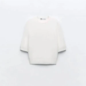 Vit stickad trekvarts tröja från Zara - Säljer en enkel och stilren vit stickad tröja från Zara. Tröjan har rund halsringning och korta ärmar. Använts 2-3 gånger.