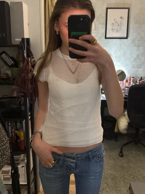 Vit stickad mesh topp - Säljer en vit stickad topp med meshdetaljer och rund hals. Toppen har en tight passform (OBS. kommer inte med linnet under🥰)