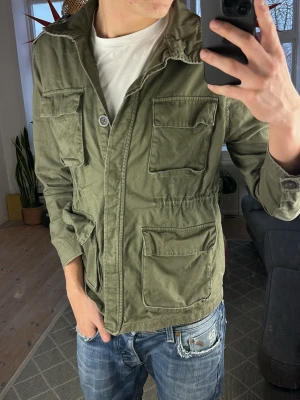 Fieldjacket olivgrön - Trendig och stilren. Mycket bra skick, mått: A:42 B:47 C:52 D:58 (cm) skriv vid fundering 😇🙌