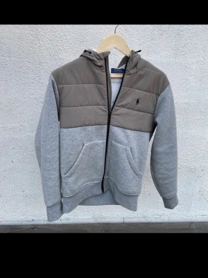 Ralph lauren cardigan grå - En grå cardigan från Ralph lauren med mjuk insida perfekt för vintern/vår! Pris kan självklart diskuteras. Ett väldigt efterfrågat och svårt plagg att få tag på.