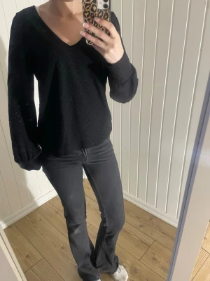Svart tröja  - Säljer en svart blus från Vila med v-ringning och långärmad modell. Blusen har broderade hålmönster över hela tyget och ballongärmar som ger en snygg siluett. Är i stolek S.💗