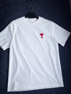 Ami Paris T-shirt  - Amir Paris T-shirt i storlek L.                                                          Färg: Vit                                                                                               Storlek: L                                                                                              Märke: Ami Paris.                                                                               Hör av dig vid frågor eller bud!