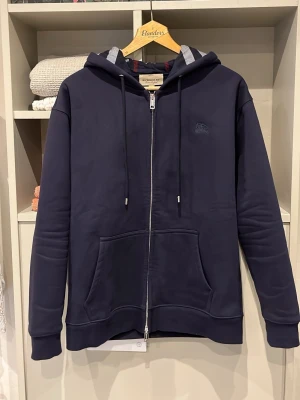 Navy Burberry Zip - Säljer denna riktigt fina o sällsynta ziphoodien från Burberry | Storlek S | Mått📏: ca 69 längd o 46 axel till axel | Tröjan är dubbeldragkedjad där det står ”burberry” på | Vid fler frågor hör gärna av er!🏌️