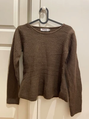 Brun stickad tröja från Missäy - HELT NY Mysig brun stickad tröja från Missäymed rund halsringning och lång ärm. Tröjan har en enkel, ribbad struktur och är perfekt för lager-på-lager under kyliga dagar. Passar dig som gillar en basic men ändå snygg look.