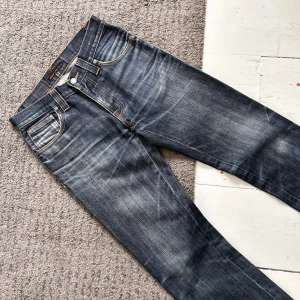 Mörkblåa Nudie Low Slim Jim Jeans - Sjukt snygga Nudie Jeans med tydliga fades. | W28 L32. | Riktigt bra skick, inga defekter! | Midja: 35-38cm (Stretch), Längd: 103cm. | Pris ej hugget i sten, skriv vid minsta fundering!