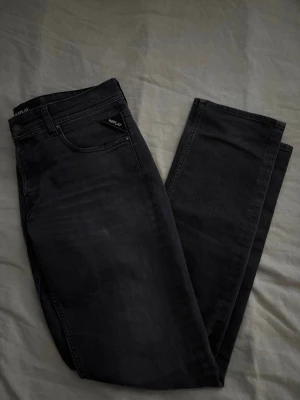Svarta Replay jeans straight fit - Säljer ett par svarta jeans från Replay med klassisk femficksdesign och raka ben. Jeansen har diskreta Replay-detaljer vid fickan och är tillverkade i ett mjukt jeansmaterial som sitter skönt. Perfekta till en avslappnad stil.