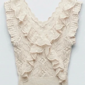 Beige spetsblus med volang från Zara - Supersöt beige blus från Zara med v-ringning, virkade spetsdetaljer och stora volanger längs axlar och halsringning. Storlek M