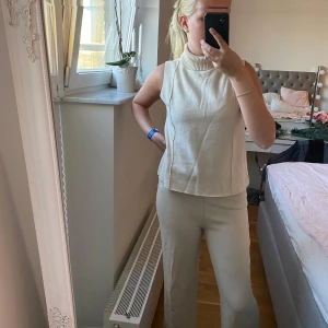 Beiget zara set women - Säljer en beige ärmlös polotopp i stickat material i storlek S. Och även ett bar beiga byxor i storlek M. Det är använt Max 2 gånger.