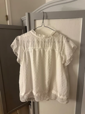 Vit blus från Only - En jättefin kortärmad blus från Only. Storleken är S och har en knapp vid nacken. Den har ett väldigt luftigt material och är tunn😇