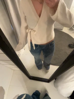 Vit kofta med knytband - Superfin vit stickad kofta från Gina Tricot med knytband i midjan och v-ringad hals. Koftan är stickad och har långa ärmar. Enkel att styla till både jeans och kjol.