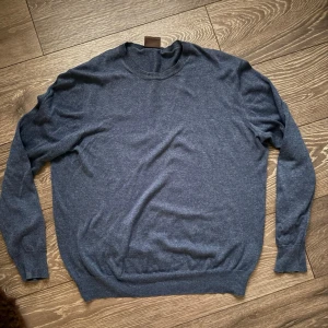 Mörkblå stickad tröja Oscar Jacobson - Säljer en mörkblå stickad tröja från Oscar Jacobson i storlek M. Tröjan har rund halsringning och långa ärmar, perfekt för lager på lager under kyliga dagar. Enkel och stilren design som funkar till det mesta.
