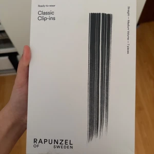 Rapunzel Classic Clip-ins Chocolate Mix - Classic Clip-ins från Rapunzel of Sweden i färgen Chocolate Mix, 40 cm långa. Sju delar med rakt, äkta hår och medium volym. Fästs enkelt med integrerade clips för en naturlig look och extra fyllighet. Perfekt för dig som vill ha längre eller tjockare hår snabbt ( pris kan diskuteras).