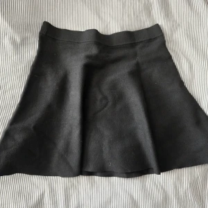 Svart kortkjol - Blev aldrig använd. En svart, enkel och stilren kortkjol från H&M. Kjolen har en lätt utställd form och bred resår i midjan för en bekväm passform. 