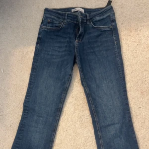 Blå jeans från Zara, storlek 36 - Snygga blå jeans från Zara i klassisk femficksmodell. Jeansen har raka ben och normal passform, tillverkade i jeanstyg med lätt tvättad look. Perfekta för dig som gillar en enkel och stilren vibe.