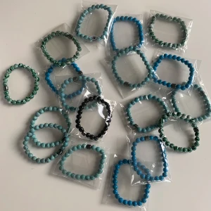 Färgglada pärlarmband i olika nyanser - Säljer flera elastiska armband med runda pärlor, finns fyra olika sorter (dem som syns på bilderna). Några har marmorerat mönster och den svarta är mer matt av sig. Perfekta att mixa och matcha för en personlig stil. Vid intresse av köp skriv till mig privat innan så sätter jag upp en specifik annons just för dig. 40kr st men pris kan diskuteras vid intresse av mer än ett armband. Och vid andra frågor och funderingar är det bara att fråga på! 