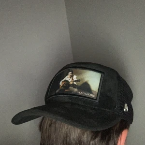 Svart Maggiore truckerkeps med motiv - Svart truckerkeps från Maggiore, inte använd mycke alls så den är i bra skick! Säljer den för halva priset ja köpte den för!