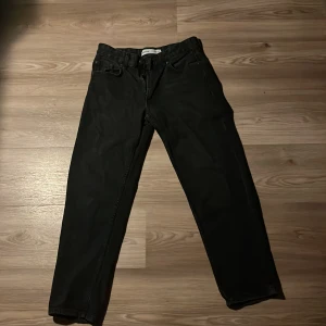 Svarta jeans från Bershka, strl 36 - Svarta jeans från Bershka i klassisk femficksmodell. Jeansen har rak passform, normal midja och dragkedja framtill. Snygga och enkla att matcha med det mesta. Perfekta för dig som gillar en stilren look.