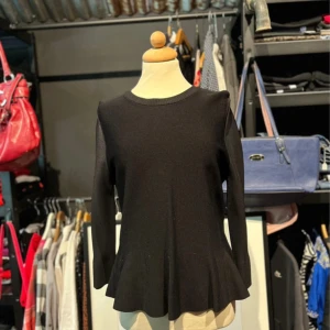 Svart stickad topp från Stockh LM - En svart stickad peplumtopp från Stockh LM med lång ärm och rund halsringning. Toppen har en lätt utsvängd volang nertill som ger en snygg siluett. Perfekt att använda både till vardags och vid festligare tillfällen.  ✨ Storlek: S/M ✨ Skick: Mycket bra ✨ Pris kan diskuteras!  💌 Tveka inte att skriva vid frågor eller funderingar 